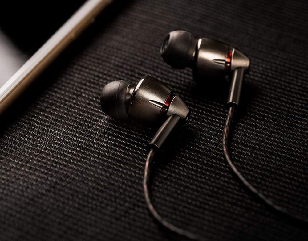 1MORE Quad-Driver Earbuds (E1010) next to phone