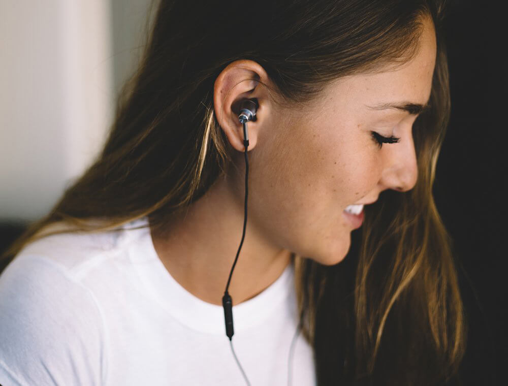 1MORE Triple-Driver Earbuds worn by woman