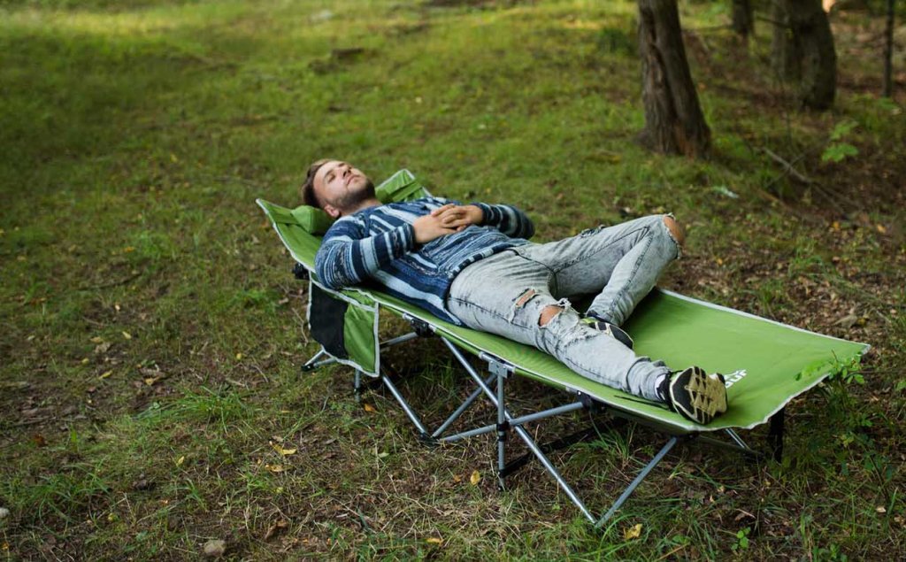 Someone sleeping on the Alpcour Folding Camping Cot