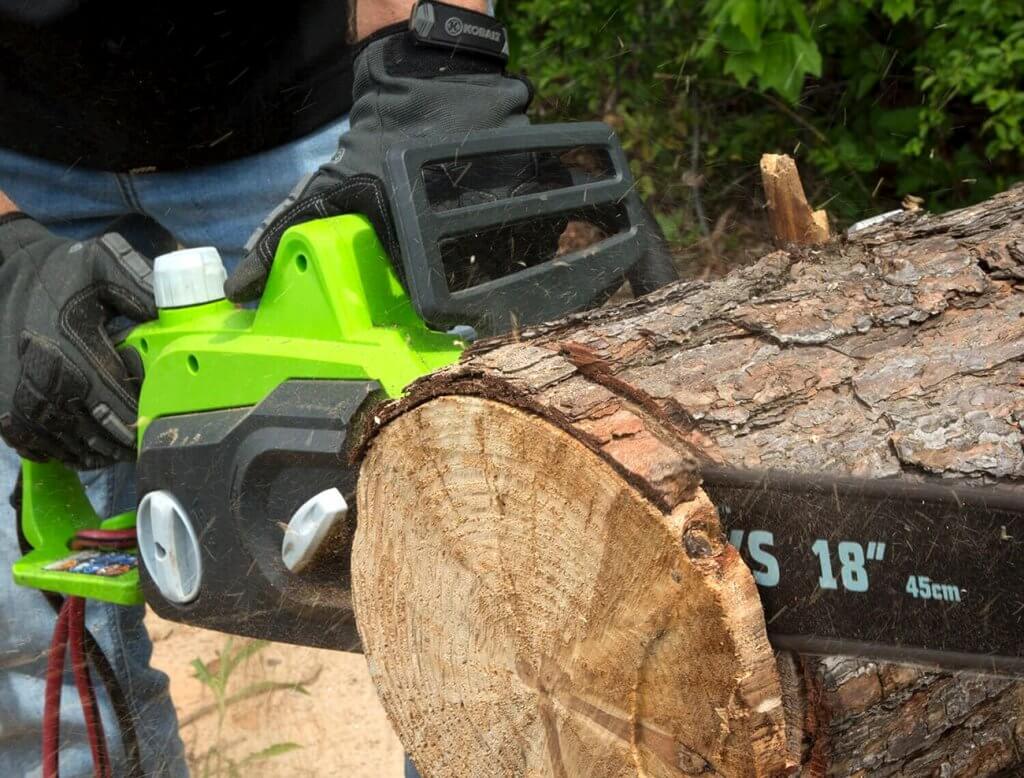 Greenworks 18-Inch Electric Chainsaw used for cutting a tree