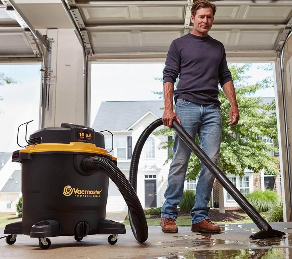 Someone using the Vacmaster Pro 16-Gallon Beast Series in a workshop