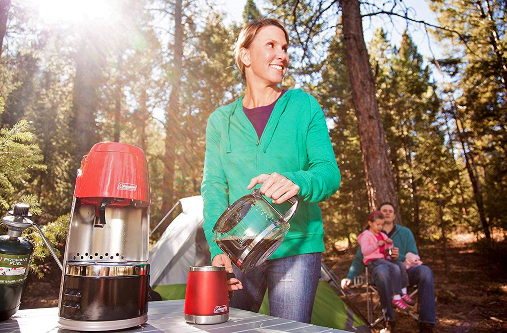 Woman making coffee on a camping trip with the Coleman QuikPot