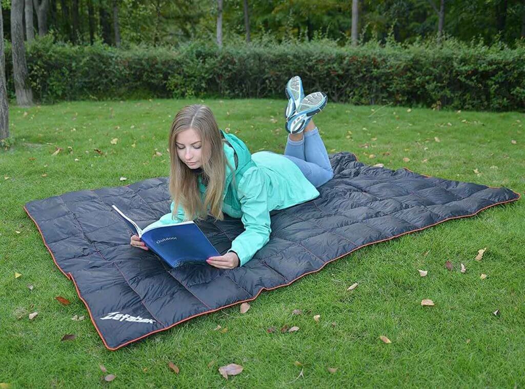 Girl reading a book on the Zefabak Camping Down Blanket